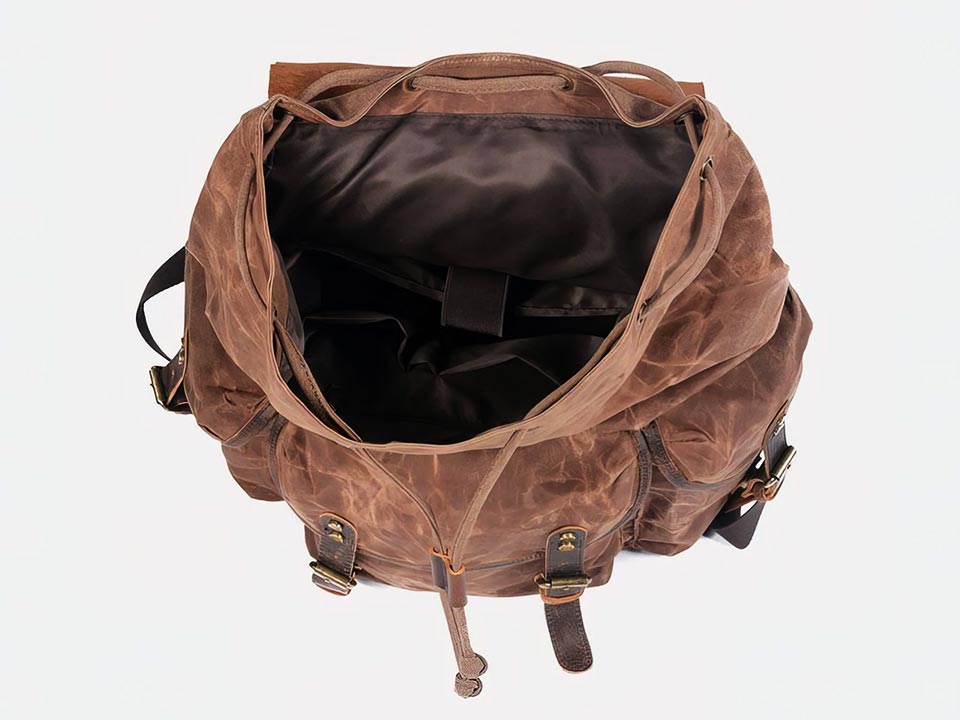Top view into the open main compartment of a coffee waxed canvas backpack