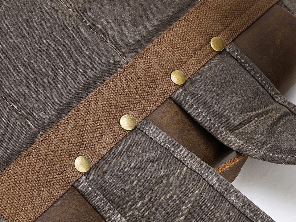 Close-up of the rivets attaching shoulder straps to a waxed canvas backpack
