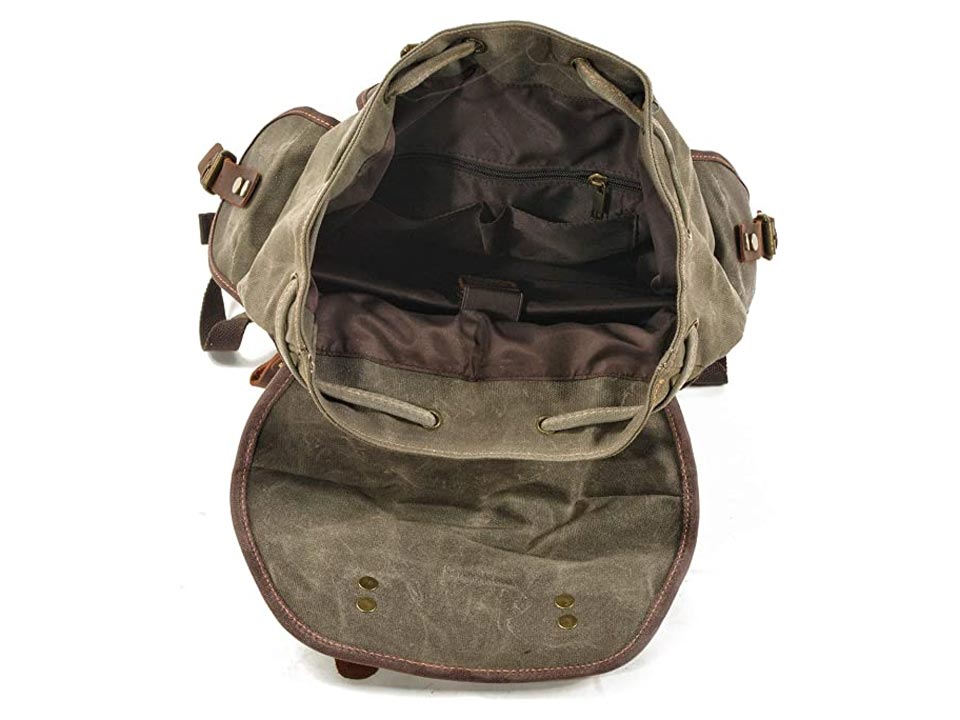 Top view into an open army green waxed canvas backpack showing the main compartment and inner pockets