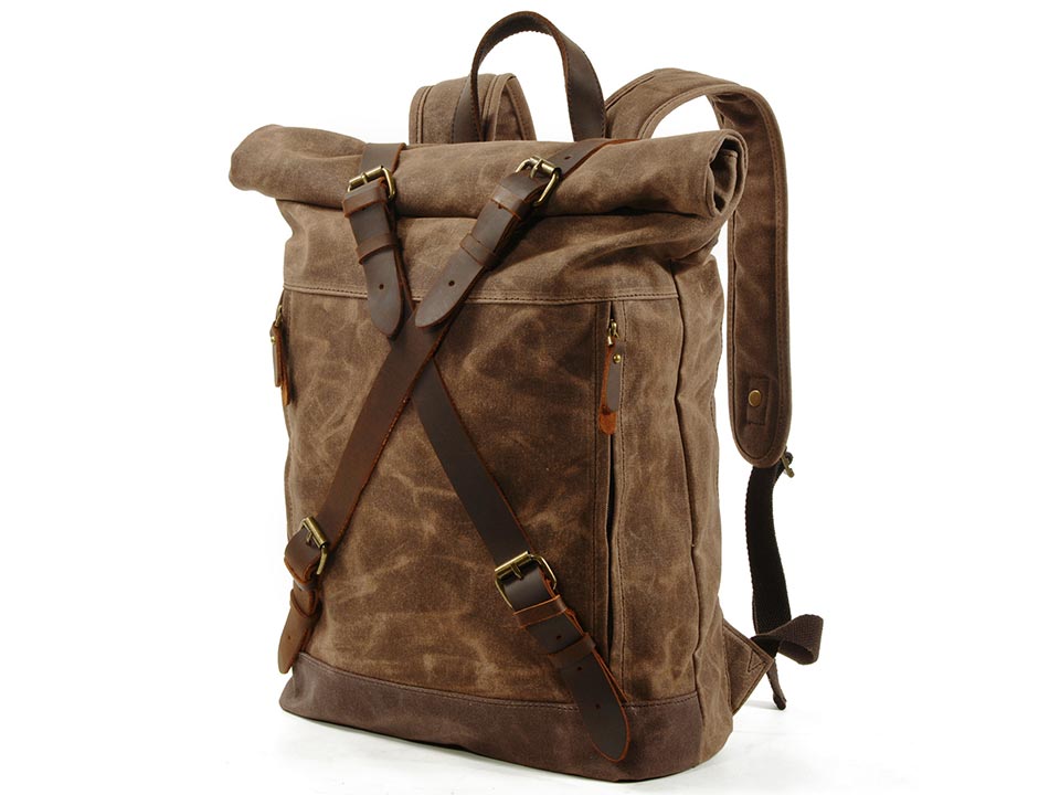 Three-quarter view of a coffee waxed canvas roll top backpack with leather buckle straps