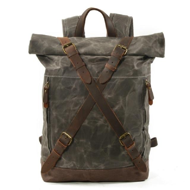 Celadon roll-top backpack showing its waxed canvas body and leather trim from the front