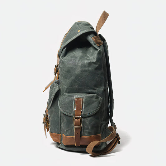 Right side of lake green waxed canvas backpack with covered pocket and leather fastening strap.