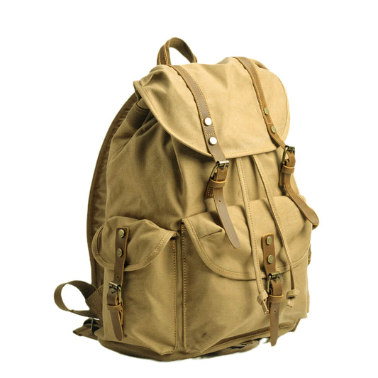 Khaki canvas backpack at an angle, showing covered side pocket and leather fastening straps.
