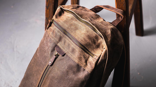 Waxed canvas backpack with a zippered top, front zip pocket and carry handle
