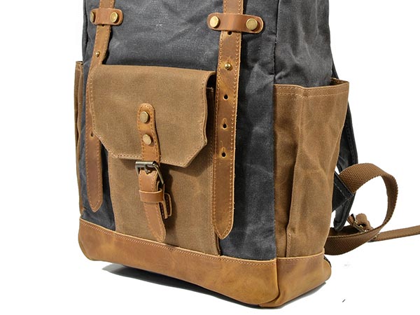 Front and side pockets with leather trim on a waxed canvas roll top backpack