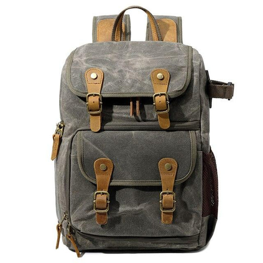 Army green waxed canvas camera backpack with a flap closure and two buckled front pockets