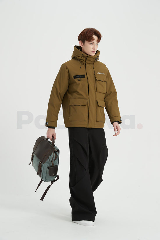 Man mid-step carrying a blue waxed canvas backpack with a leather flap by its top handle