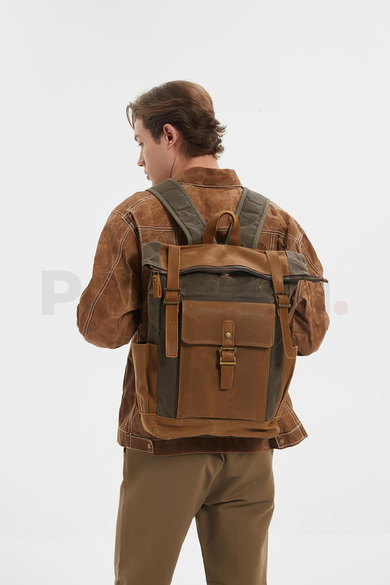 Rear view of a man wearing a coffee waxed canvas roll top backpack with a leather front pocket