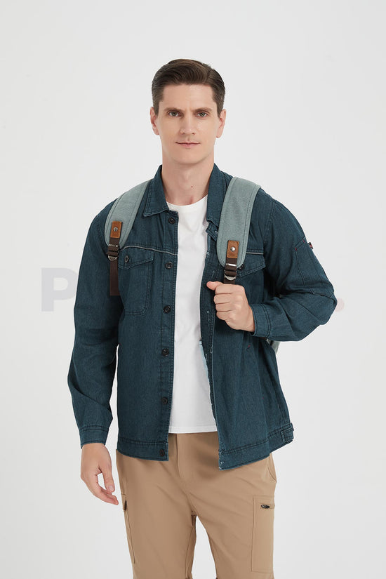 Front view of a man holding a shoulder strap of his blue waxed canvas backpack