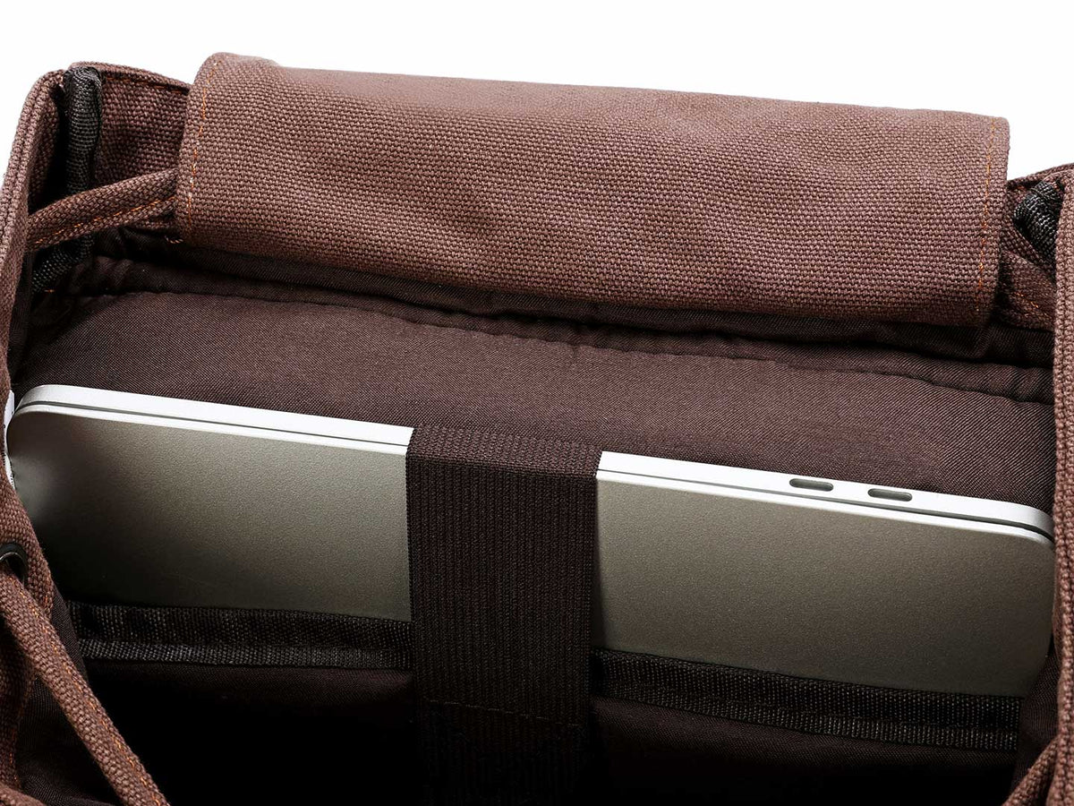 Laptop secured inside the padded sleeve of a coffee canvas backpack
