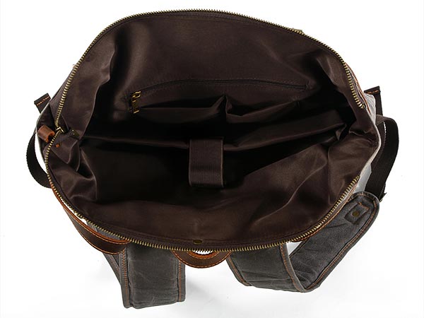 Open waxed canvas backpack showing a padded laptop sleeve, retaining strap and inner pockets