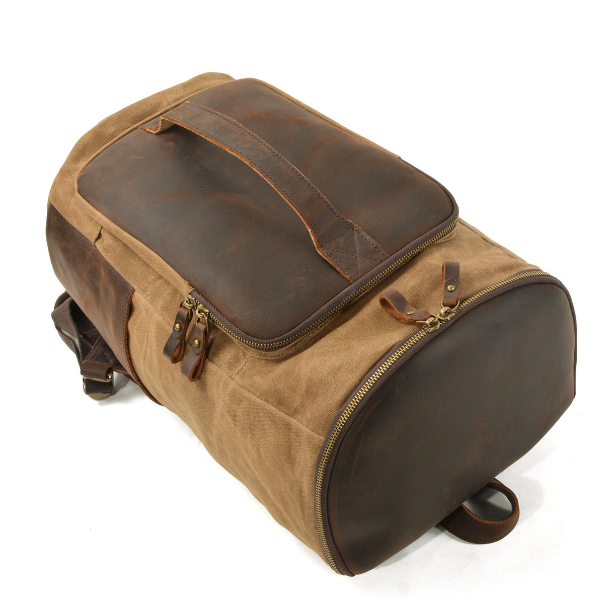 Backpack lying flat to show its zippered base and long leather front handle