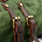 Close-up of the brass buckles on the Army backpack front straps.