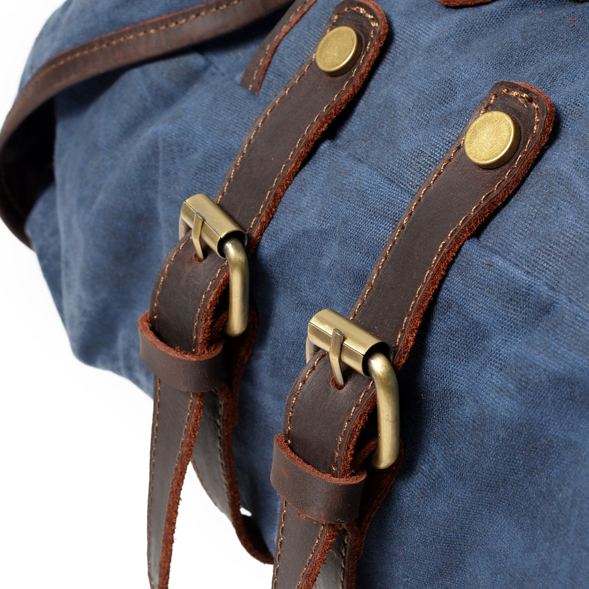 Brass buckles on the Blue backpack's leather straps.
