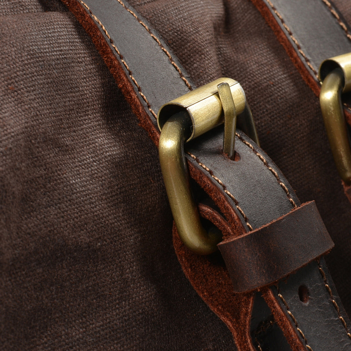 Brass buckle on a leather strap of the Coffee backpack.