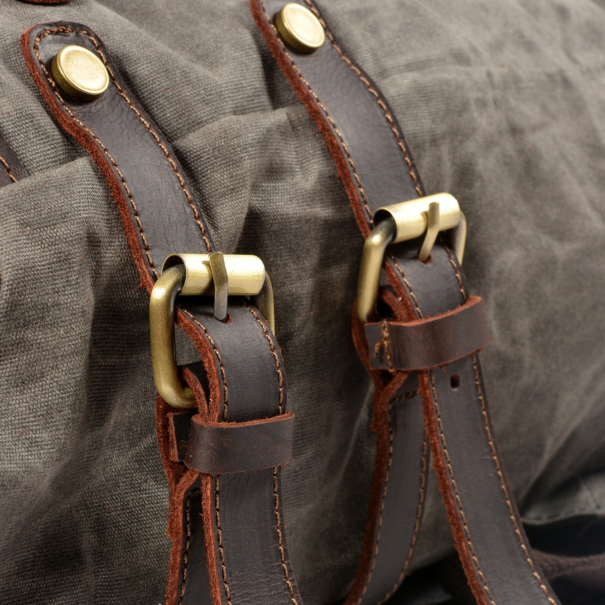 Brass buckles on the Gray backpack's leather straps.