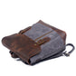 Gray backpack lying on its side with the buckled leather flap