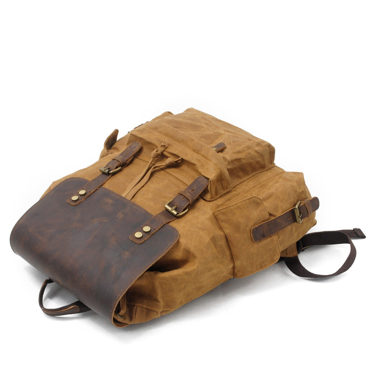 Khaki waxed canvas backpack lying flat with the flap buckled
