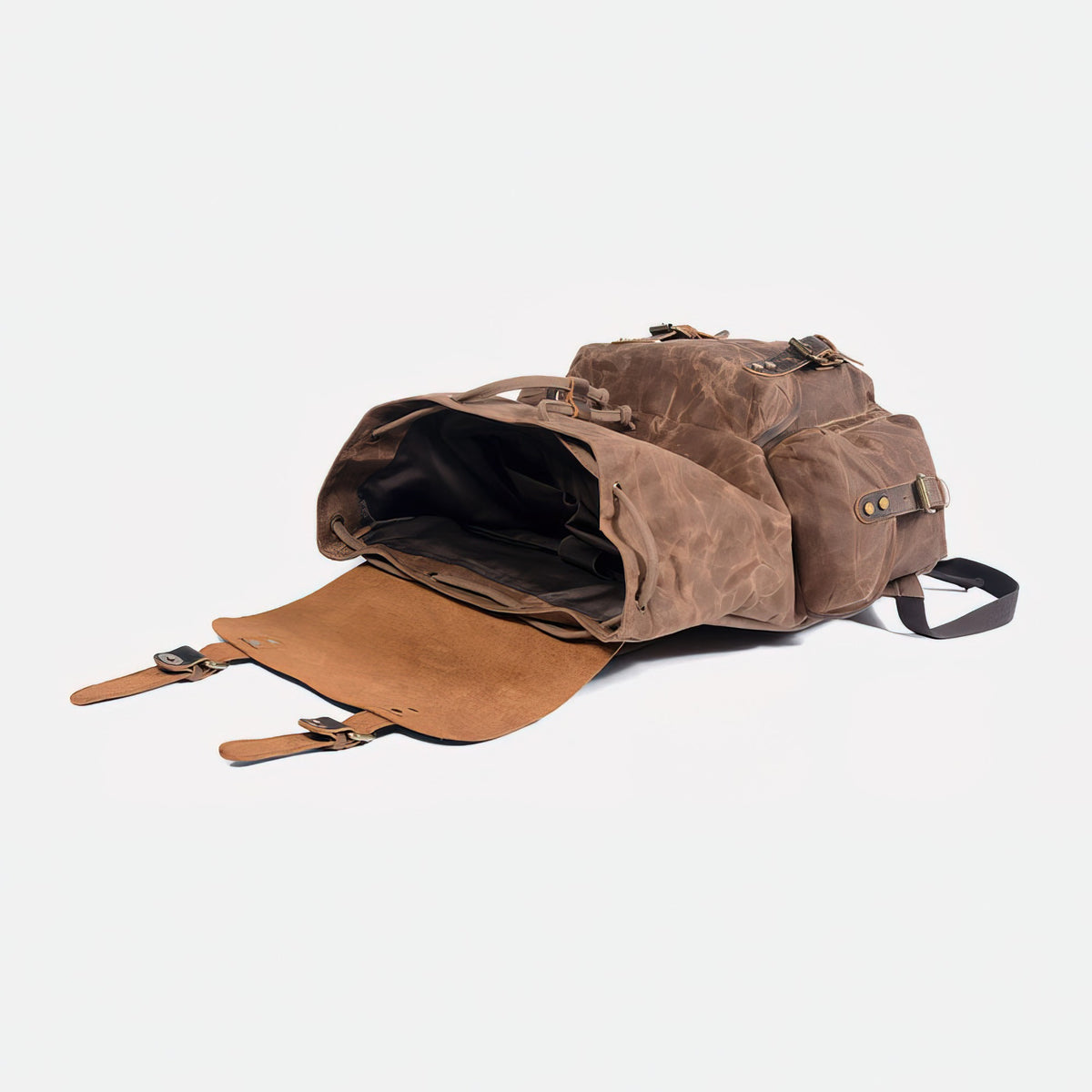 Coffee waxed canvas backpack lying down with leather flap open and main compartment visible.