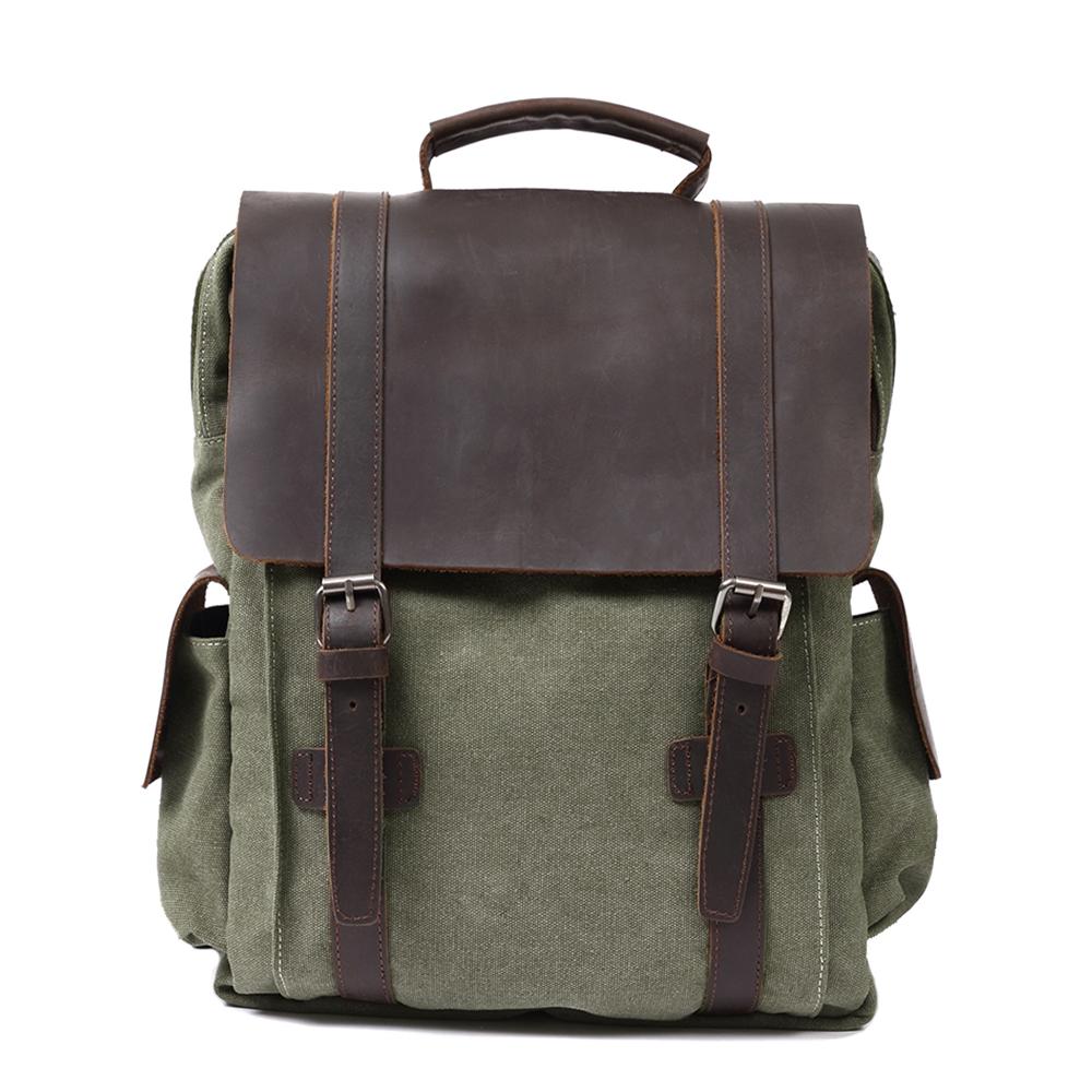 Front of army green waxed canvas backpack with broad leather flap and twin buckle straps.