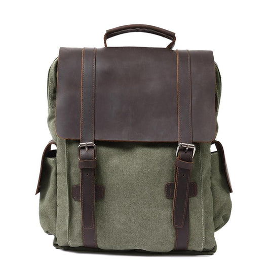 Front of army green waxed canvas backpack with broad leather flap and twin buckle straps.