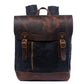 Black water-resistant waxed canvas school backpack with a brown leather flap and base