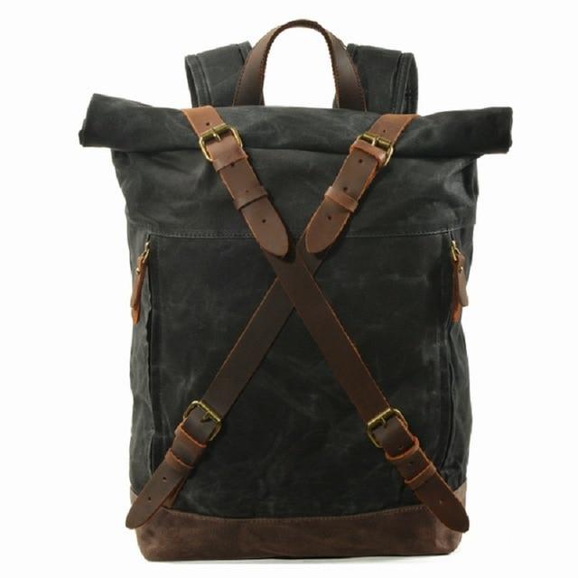 Front of the Black canvas backpack, its rolled opening held by crossed leather straps