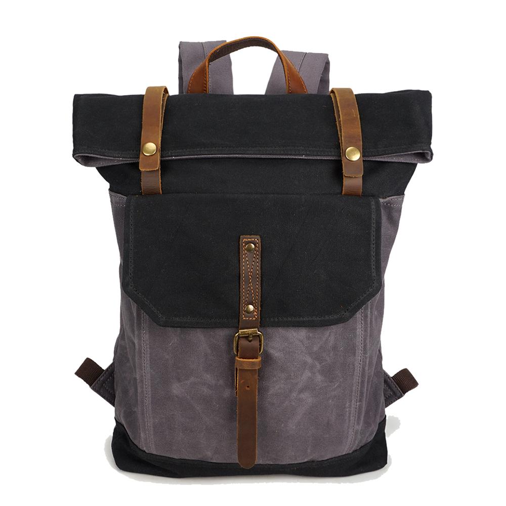 Black and gray vintage waxed canvas roll top backpack with a leather buckle strap