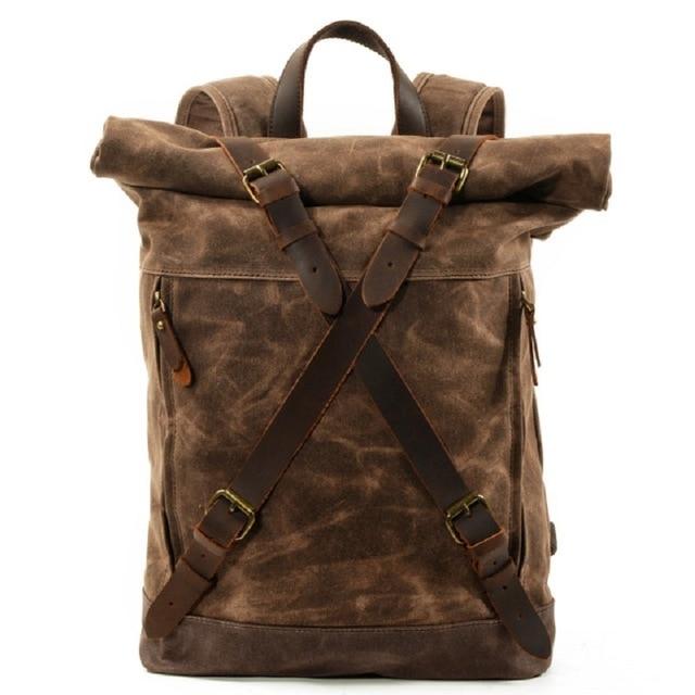 Coffee waxed canvas roll-top backpack with crossed leather straps, front view