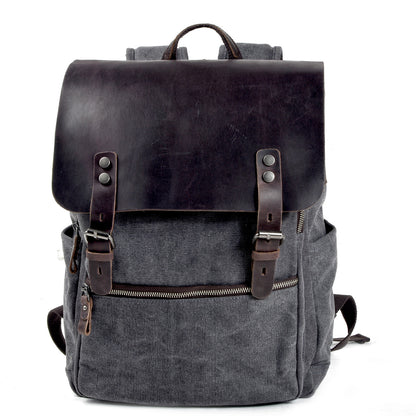 Gray canvas laptop backpack with a crazy horse leather flap, buckle straps and front zip pocket