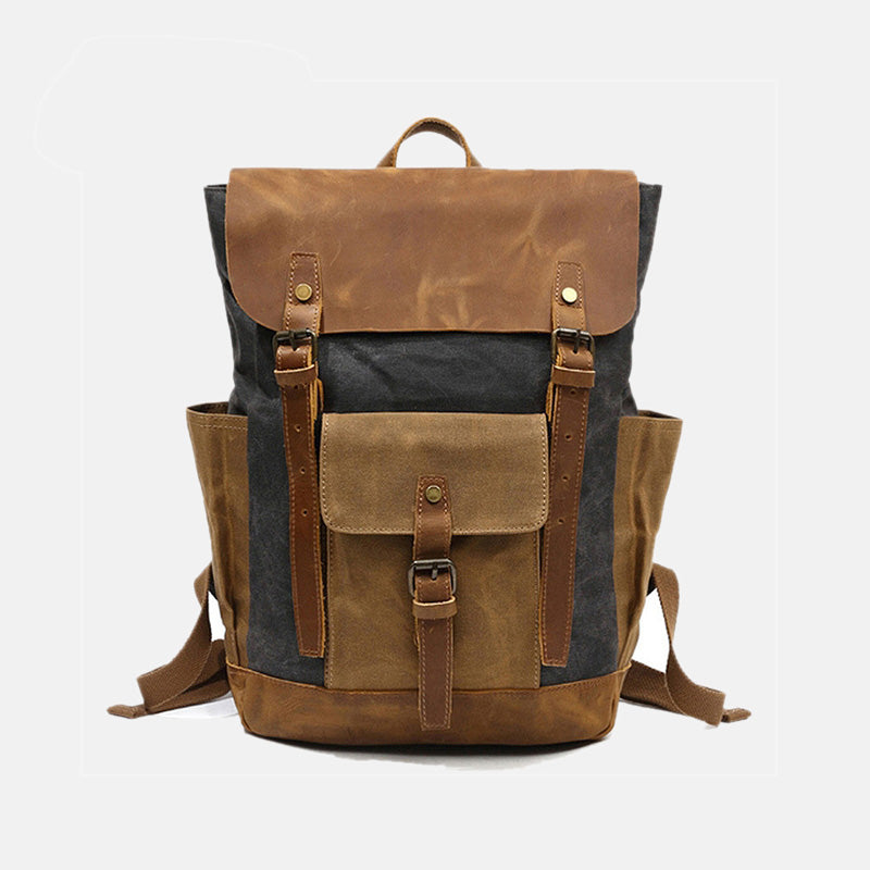 Grey waxed canvas backpack with a leather flap, twin buckle straps and a front pocket
