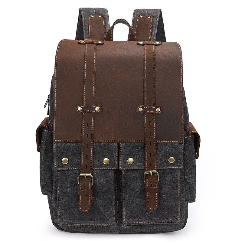 Gray waxed canvas camera backpack, front view with the leather flap and side pockets