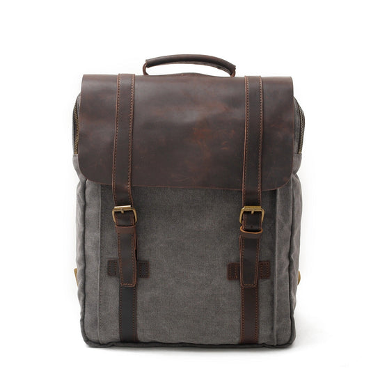 Gray canvas laptop backpack with a crazy horse leather flap and buckle straps