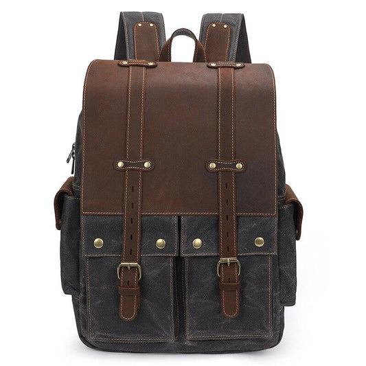 Gray waxed canvas camera backpack, front view with the leather flap and side pockets