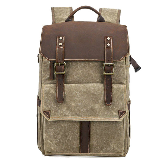 Front of khaki waxed canvas backpack with leather flap, twin buckle straps and front pocket.