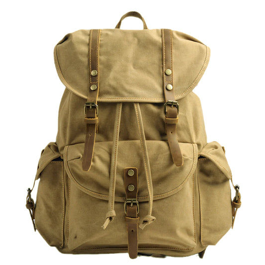 Front of khaki canvas backpack with drawstring opening, leather buckle straps and three flap pockets.