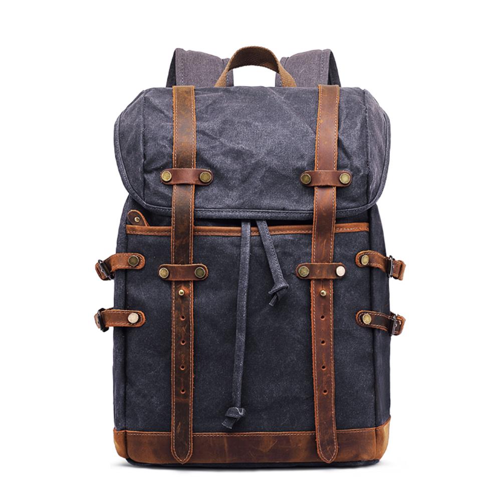 Navy waxed canvas vintage laptop backpack with brown leather straps and side buckles