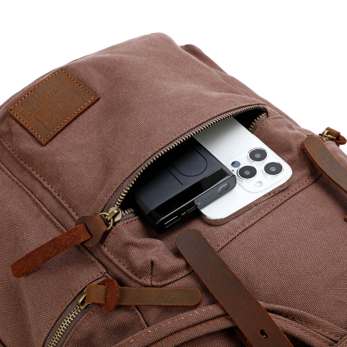 Phone and small electronic accessories in the front zip pocket of coffee canvas backpack.
