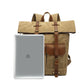 Roll top backpack next to a 15.6 inch laptop to show the fit