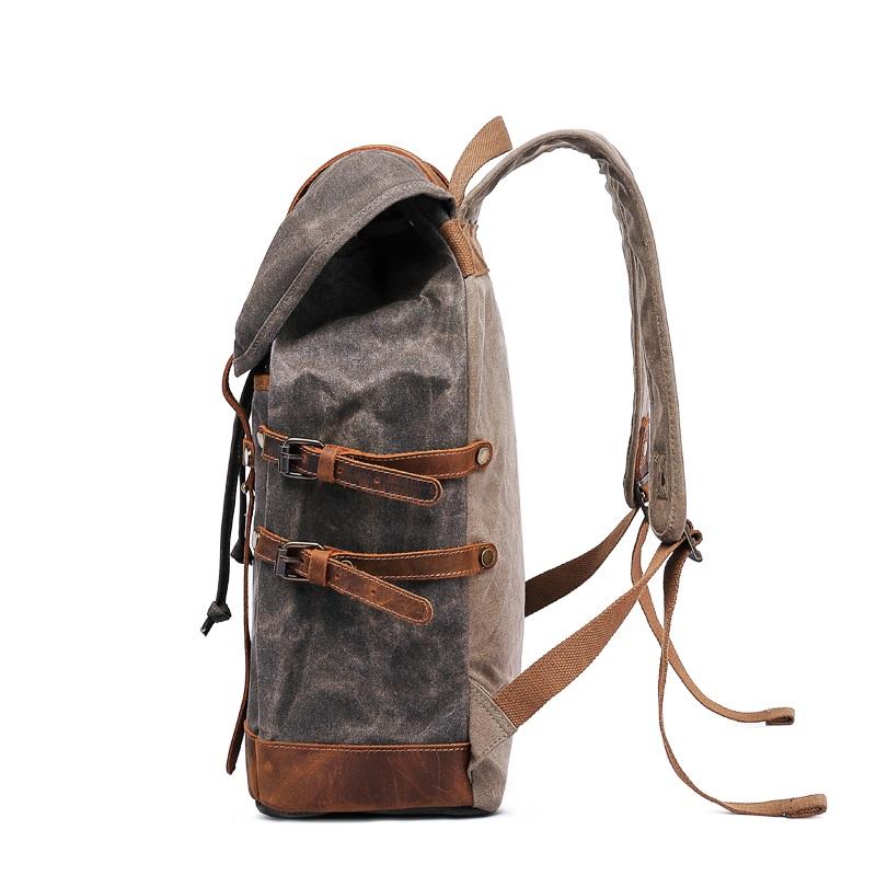 Left-side profile of the Gray backpack showing the buckled straps and padded shoulder strap.