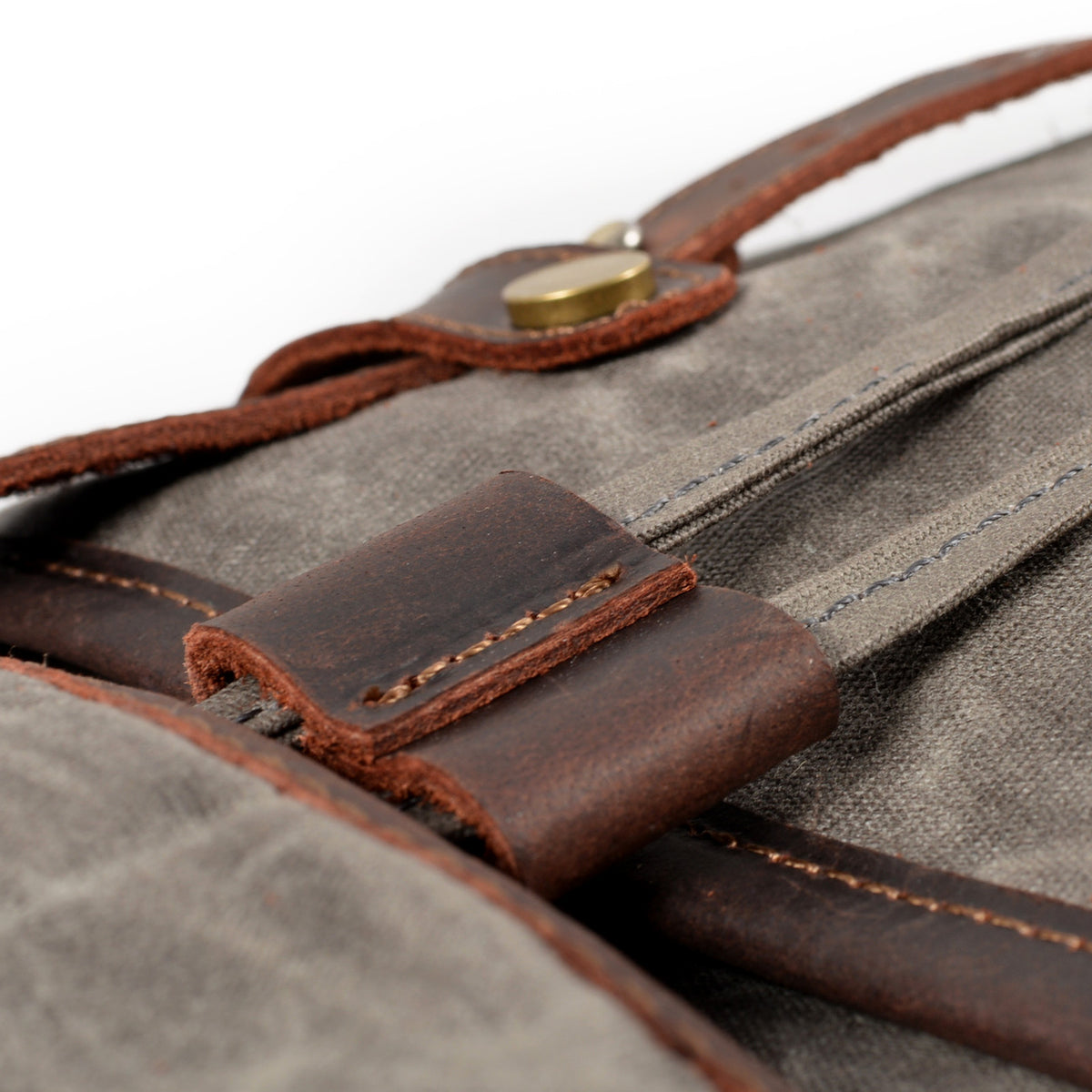 Leather loop and stitching detail on the gray backpack