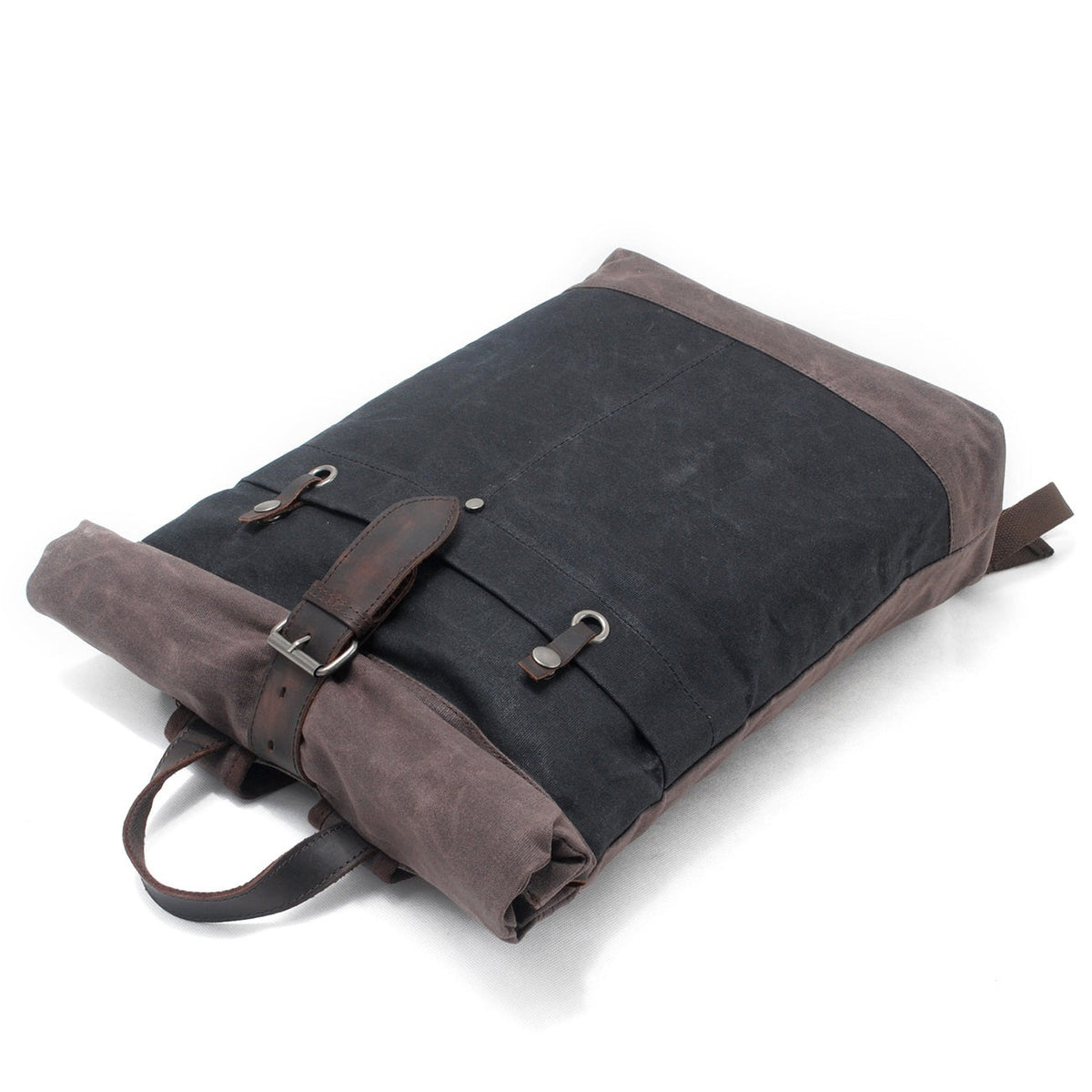 Black roll top backpack lying flat with the strap fastened