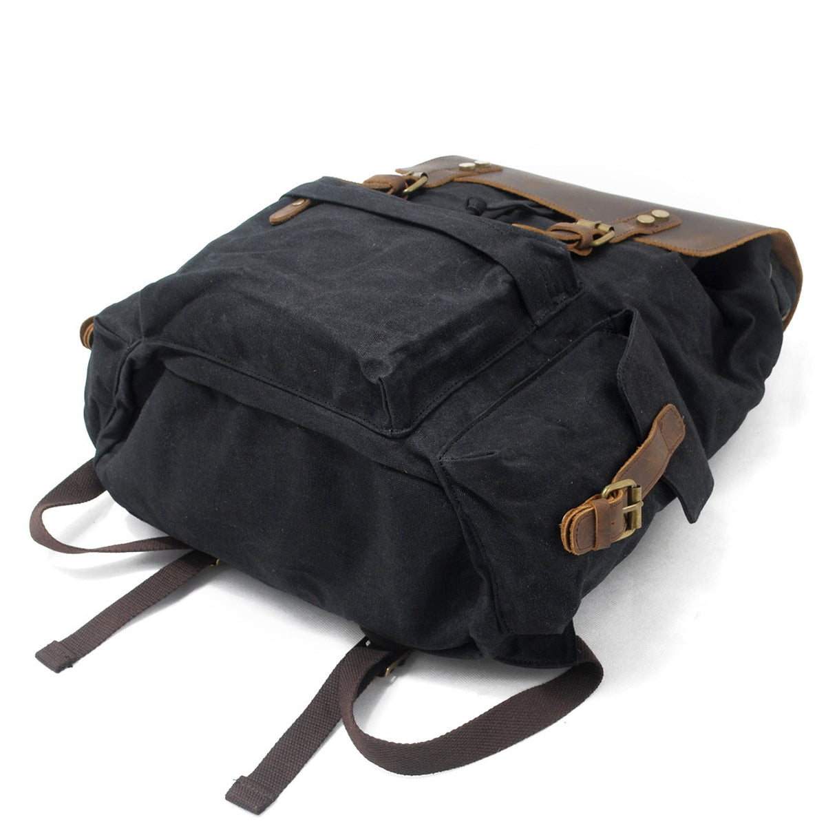 Black waxed canvas backpack showing its exterior side pocket and leather buckle.