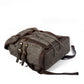 Gray waxed canvas rucksack showing its exterior side pocket and leather buckle.
