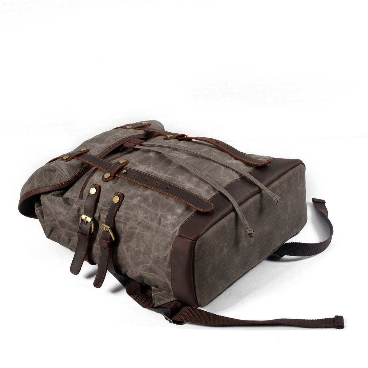 Gray waxed canvas rucksack showing its exterior side pocket and leather buckle.