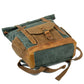 Lake green roll top backpack lying on its base with the front pocket up