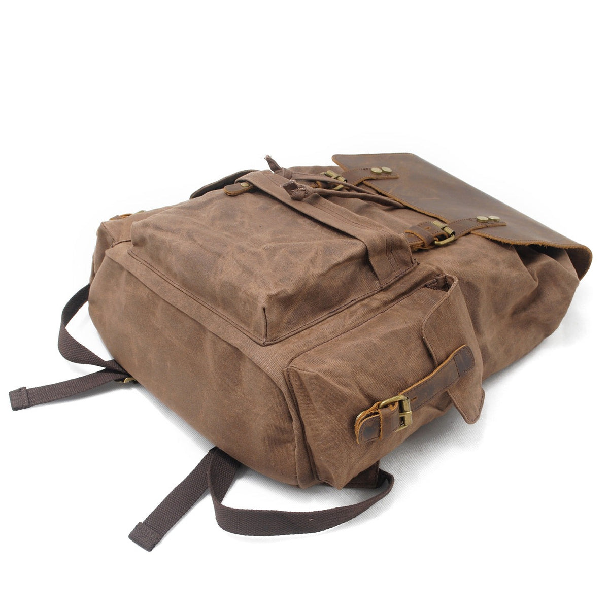 Brown waxed canvas backpack showing its exterior side pocket and leather buckle.