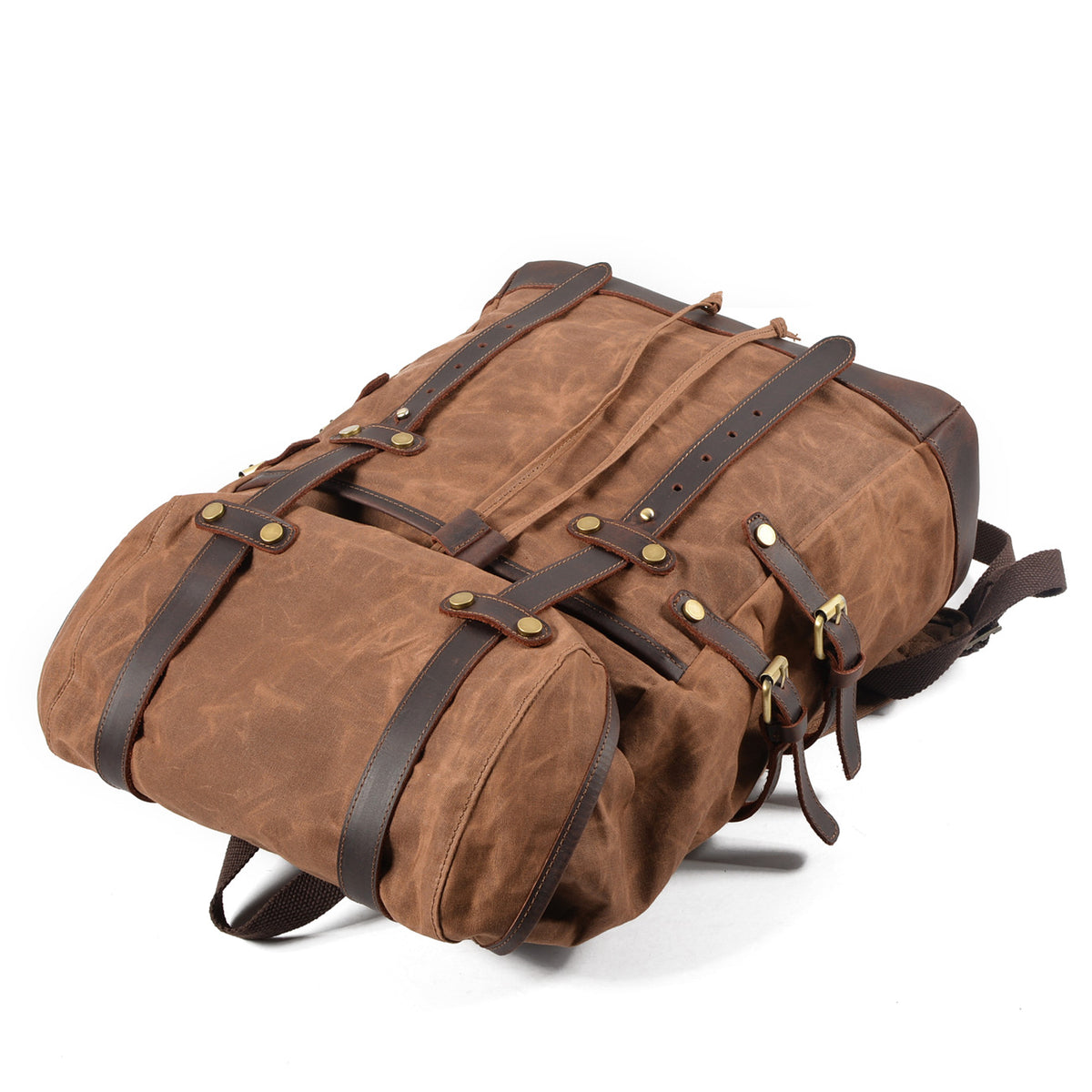 Brown waxed canvas backpack lying flat with its leather straps fastened.