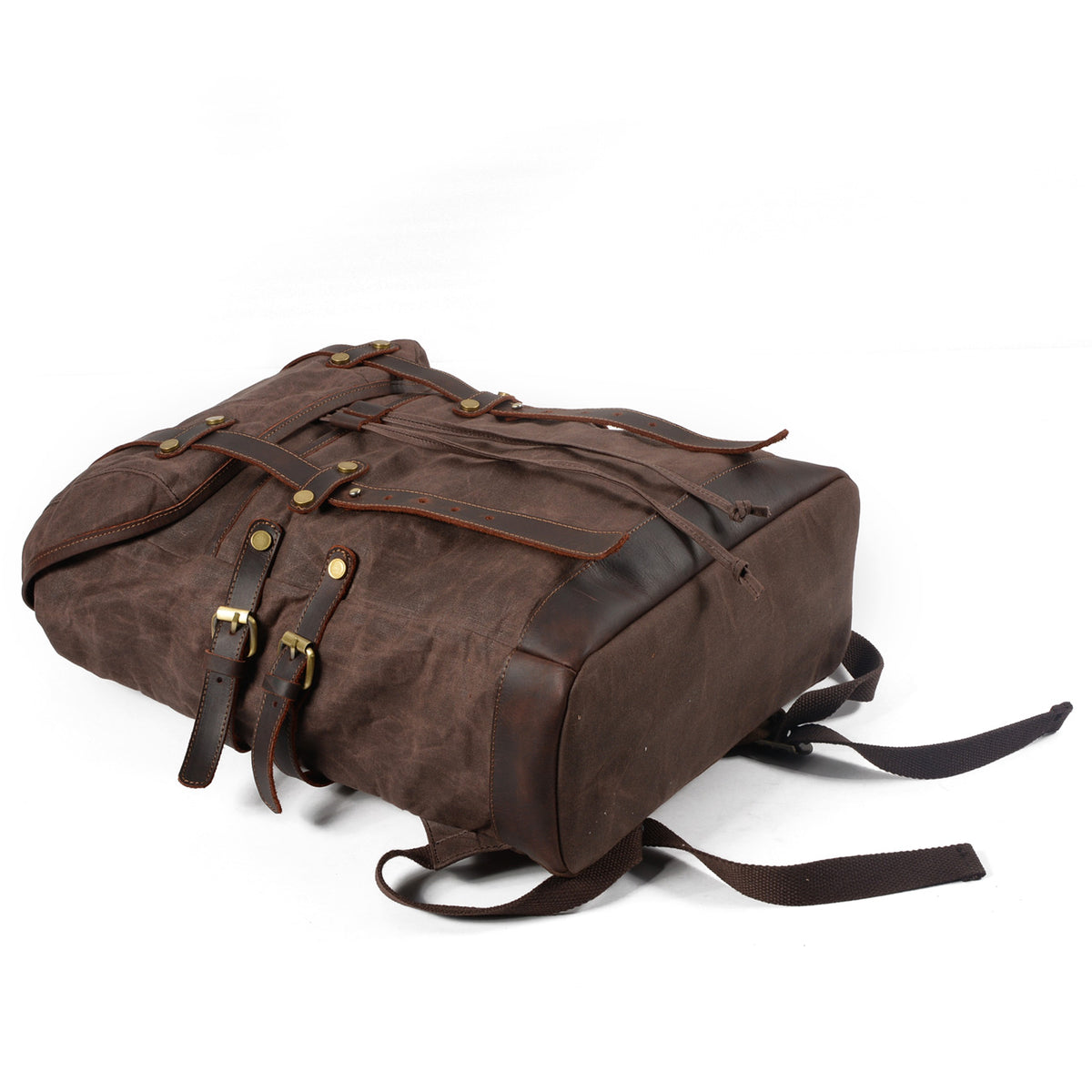Front panel of the Coffee waxed canvas backpack lying flat with its straps fastened.