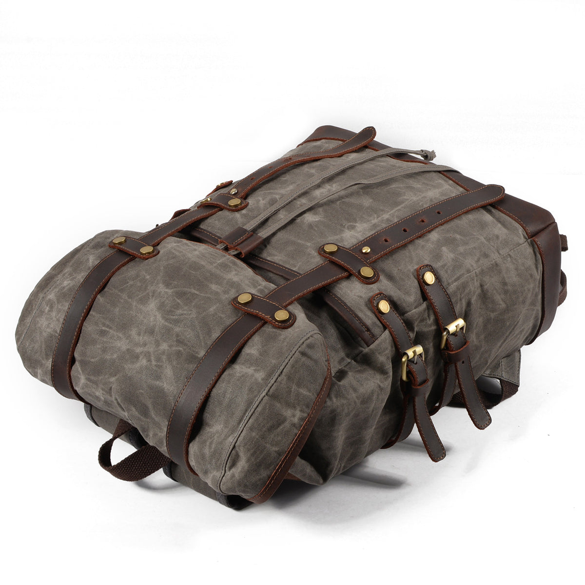 Gray waxed canvas rucksack lying flat with straps fastened